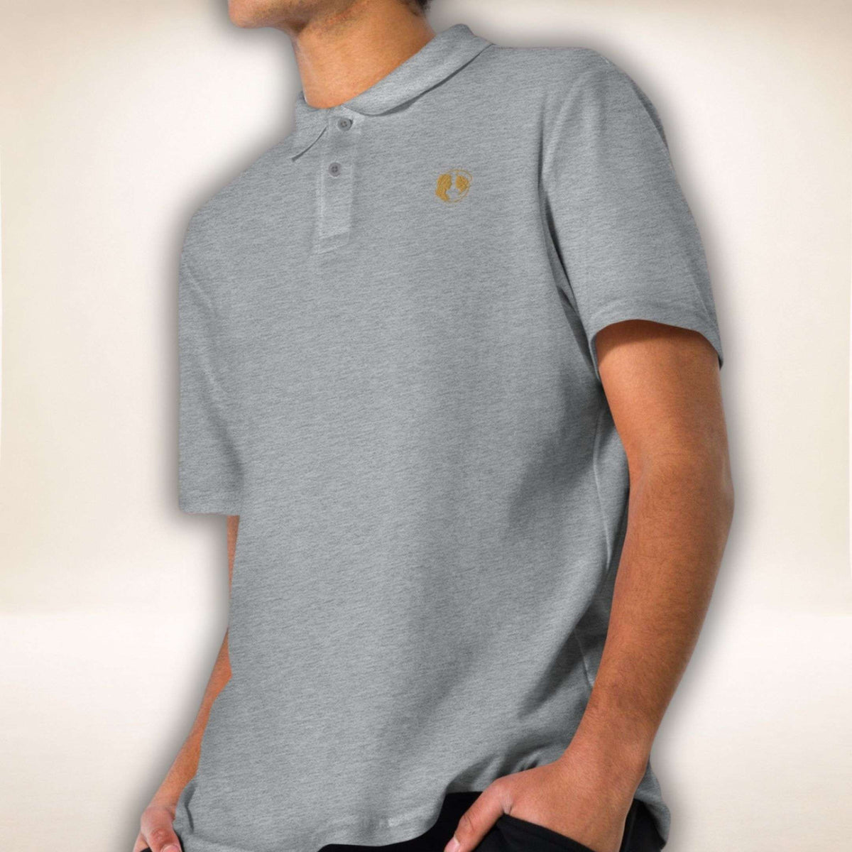 Graues Belgravia Poloshirt mit goldfarbenem Doppelprofil-Logo, von einem Mann getragen