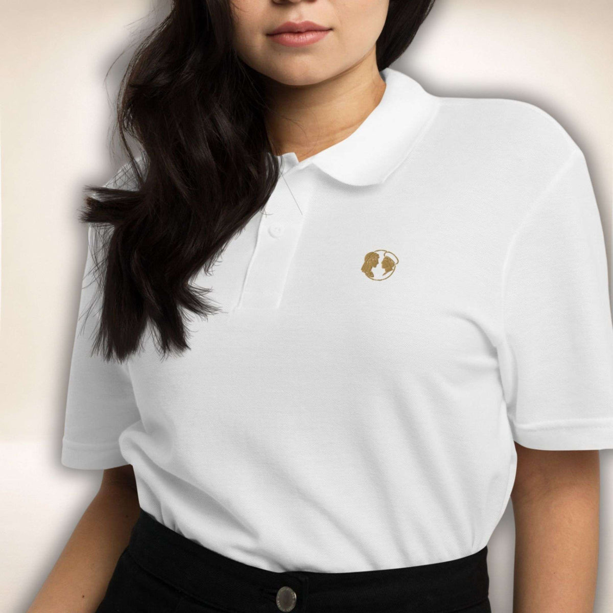 Weißes Belgravia Poloshirt mit goldfarbenem Doppelprofil-Logo, von einer Frau getragen