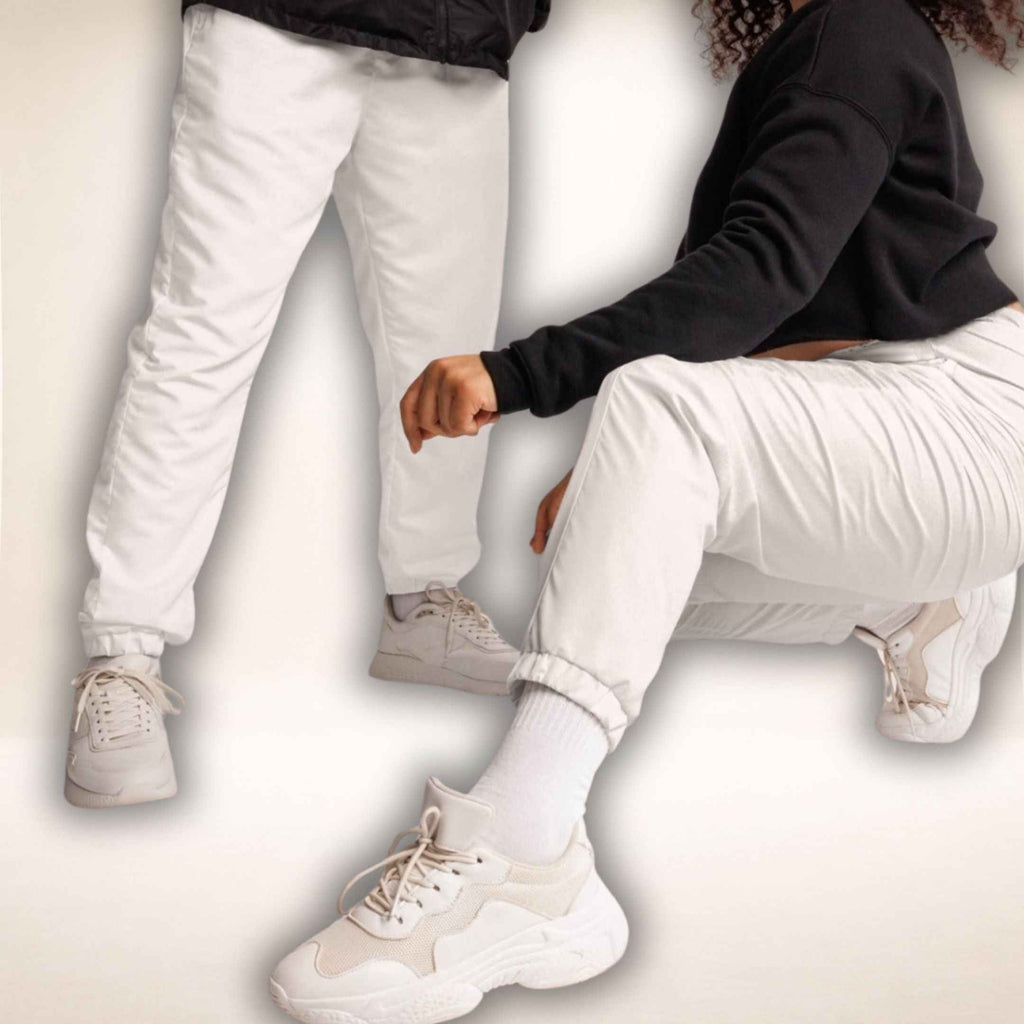 Weiße Hose Riviera Ease mit schmaler zulaufenden Beinen, zwei Ansichten am Model mit Sneakern