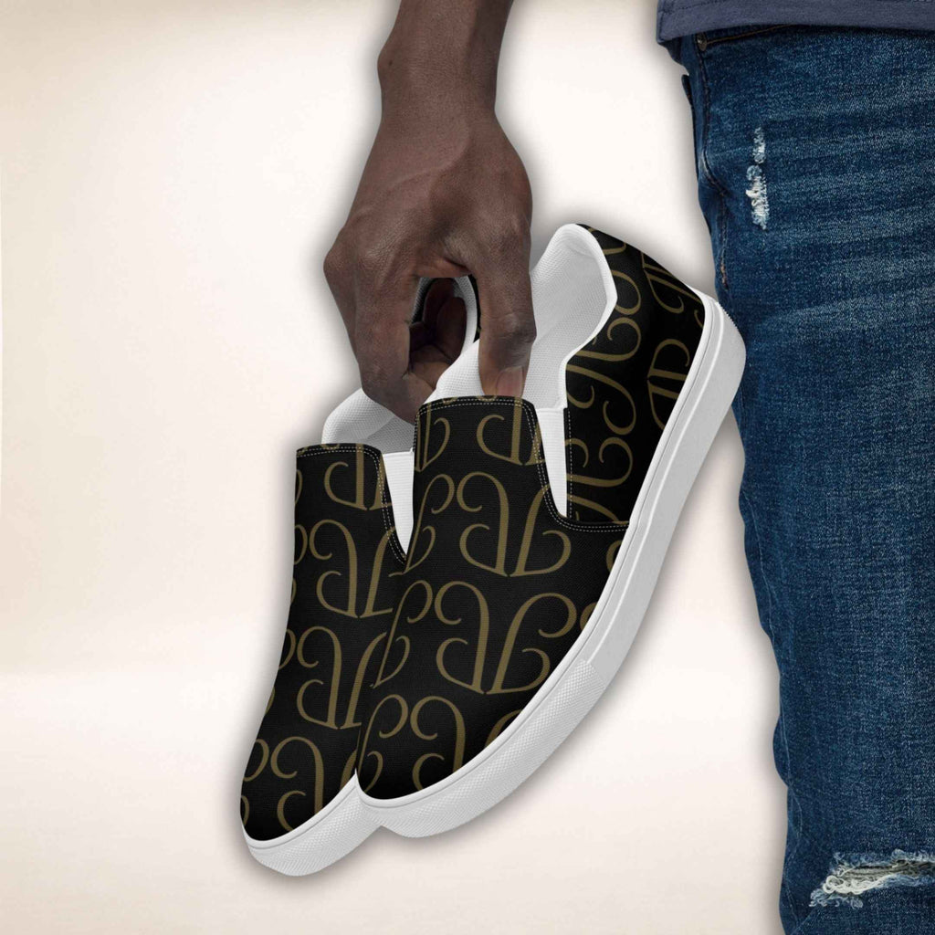 Slip-On Sneaker Monogram Luxe mit goldfarbenem Muster und weißer Sohle, in einer Hand gehalten